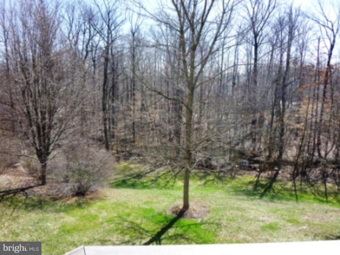 9229 Howland Road Laurel, MD 20723 - Photo 13 of 15 a backyard of a house with a yard and large trees