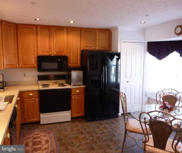 9229 Howland Road Laurel, MD 20723 - Photo 9 of 15 a kitchen with stainless steel appliances granite countertop a refrigerator and a stove top oven