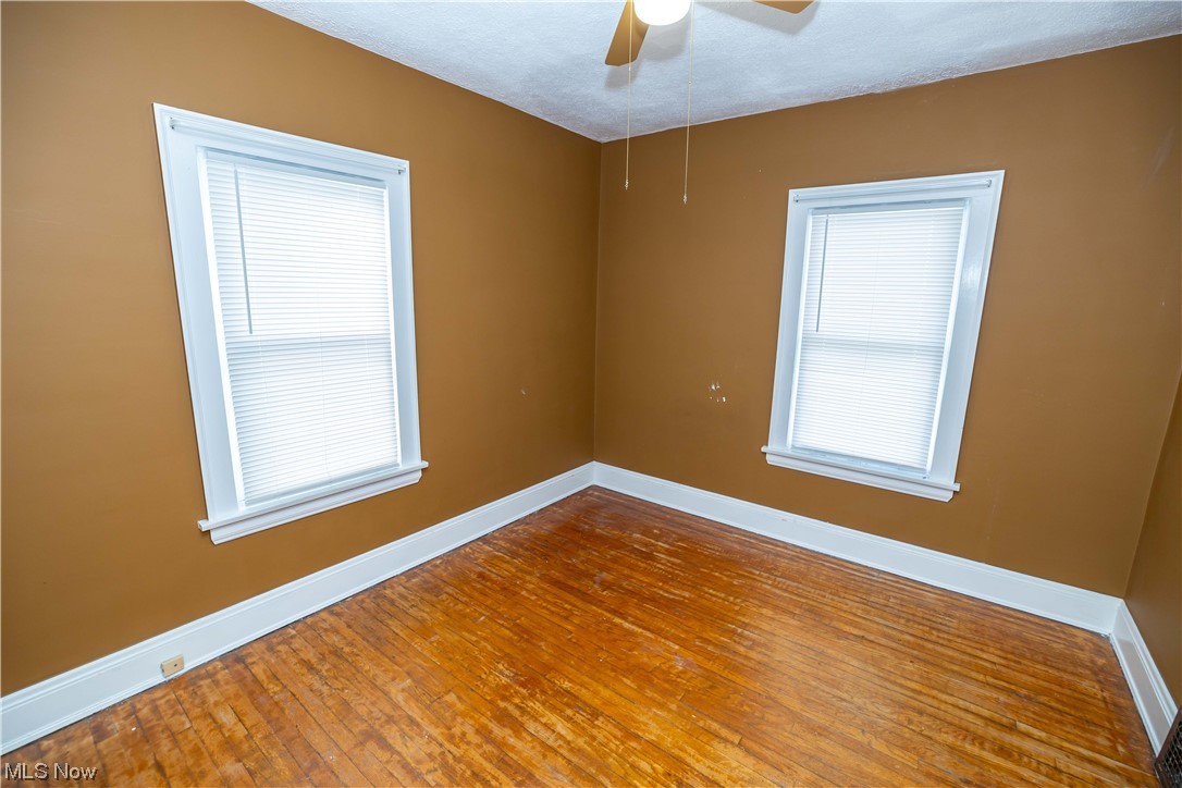 10105 Unity Avenue Cleveland, OH 44111 - Photo 13 of 35 Empty room with dark hardwood flooring and ceiling fan
