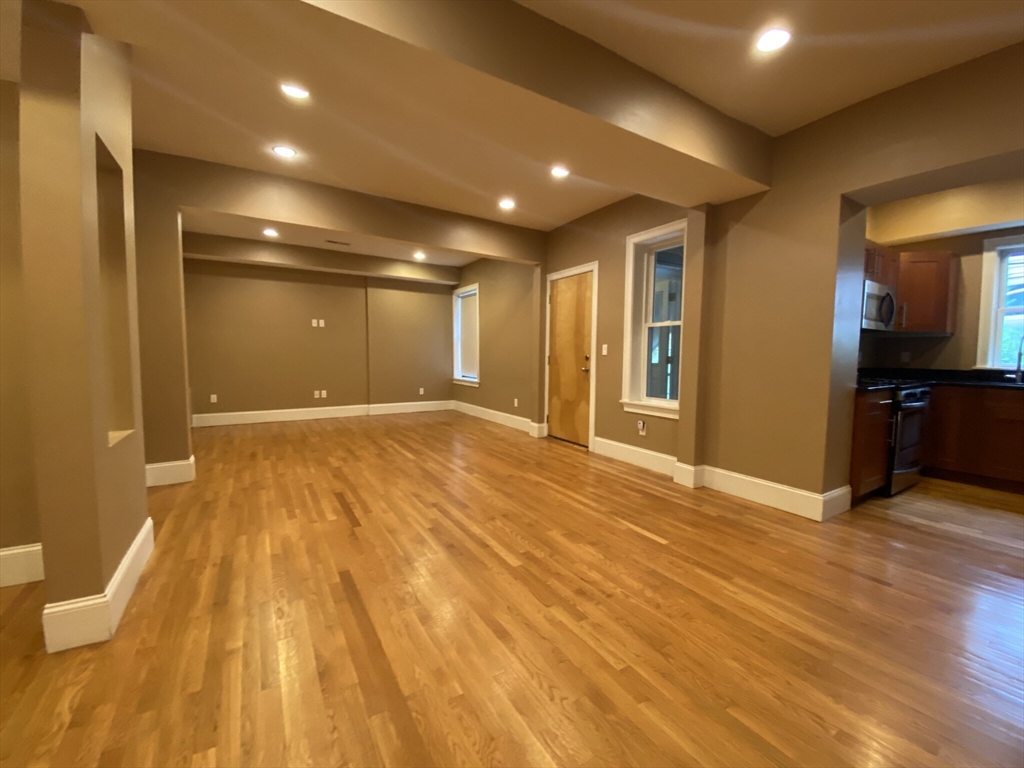 1592 Beacon Street, Unit 3 Brookline, MA 02446 - Photo 2 of 10 a view of an empty room with wooden floor and a bathroom