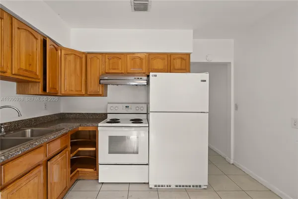 a white refrigerator freezer sitting in a kitchen with white cabinets