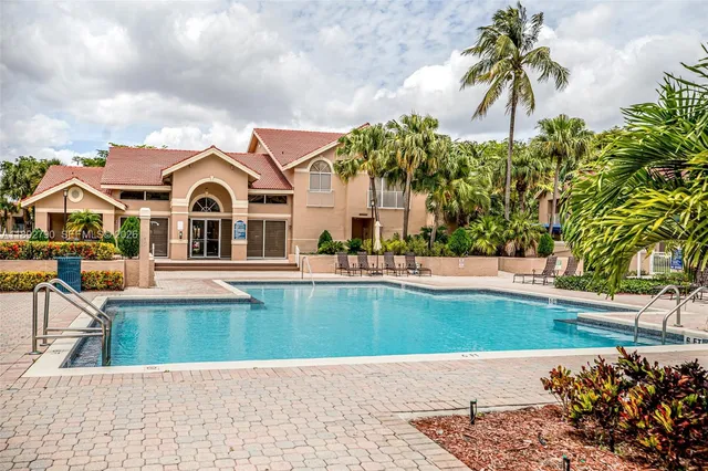 a view of a house with swimming pool and sitting area