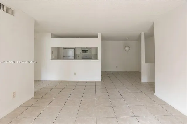 a large white kitchen with stainless steel appliances a refrigerator a sink and a stove