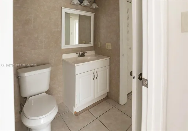 an empty room with closet and a ceiling fan