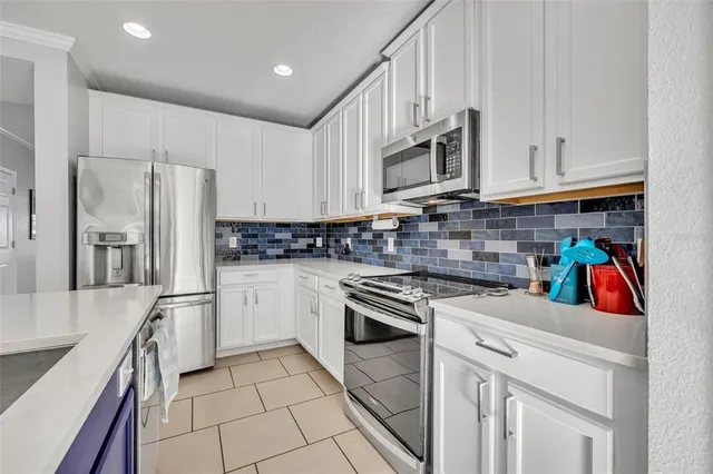 a kitchen with stainless steel appliances granite countertop a refrigerator sink and stove