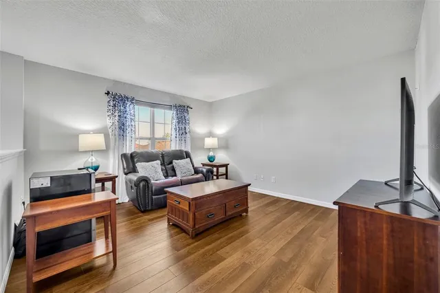 a living room with furniture flat screen tv and window