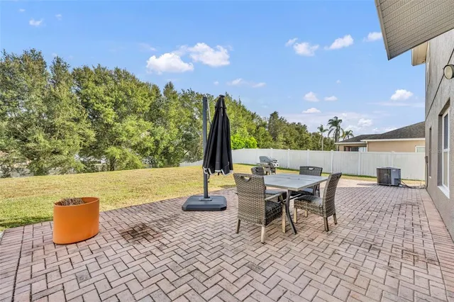 a view of a patio with a table and chairs and potted plants