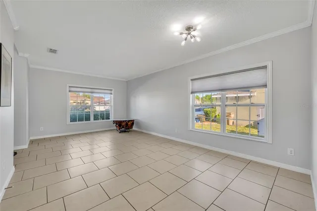 an empty room with windows and ceiling fan