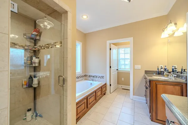 a large bathroom with a tub sink and mirror