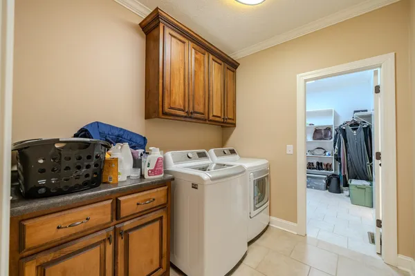 a utility room with cabinets washer and dryer