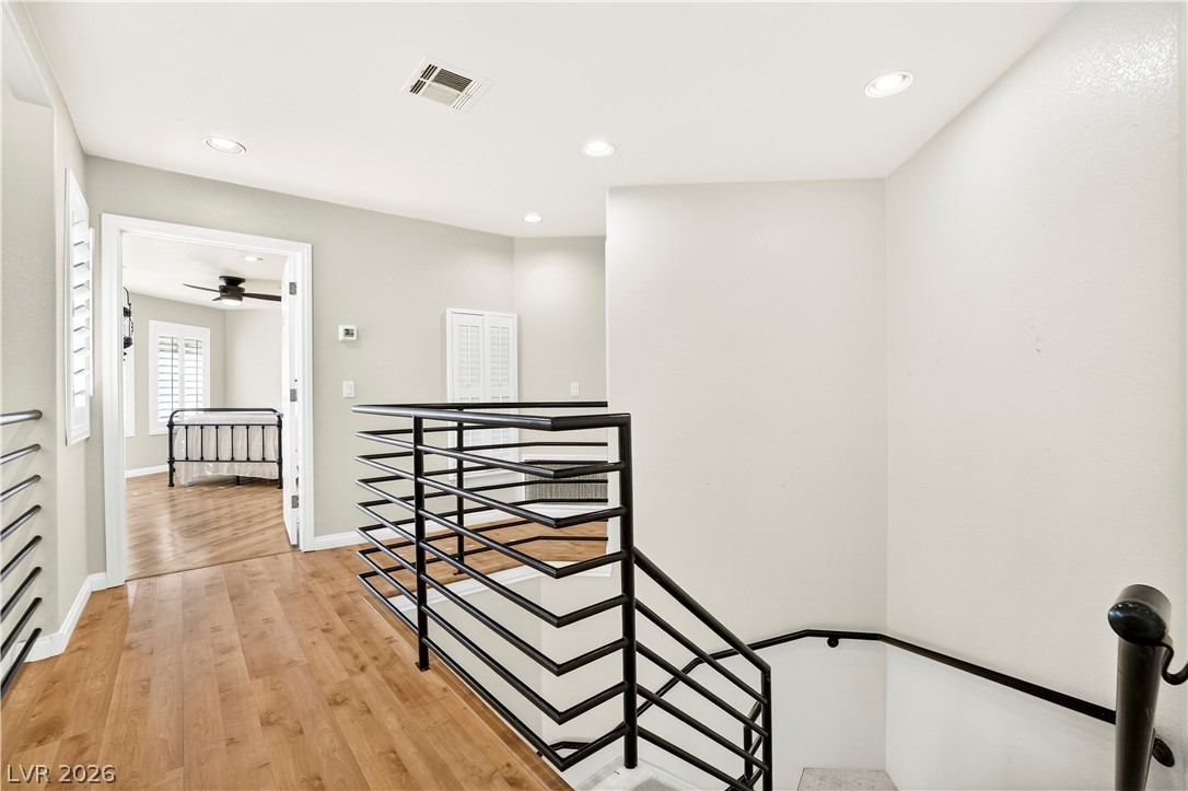 1135 Calico Ridge Drive Henderson, NV 89011 - Photo 45 of 86 A well-lit landing features wood-look flooring and a sleek metal railing.