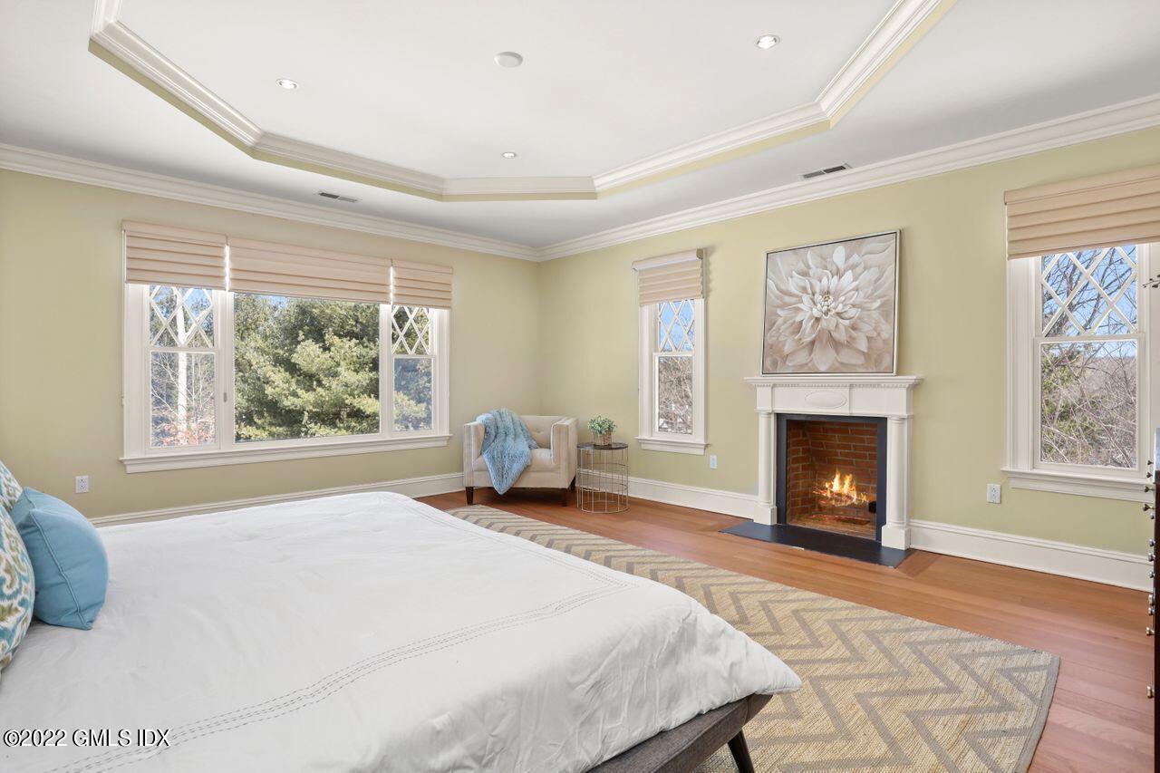 56 Frontier Road Cos Cob, CT 06807 - Photo 20 of 32 a spacious bedroom with a large bed and a fireplace