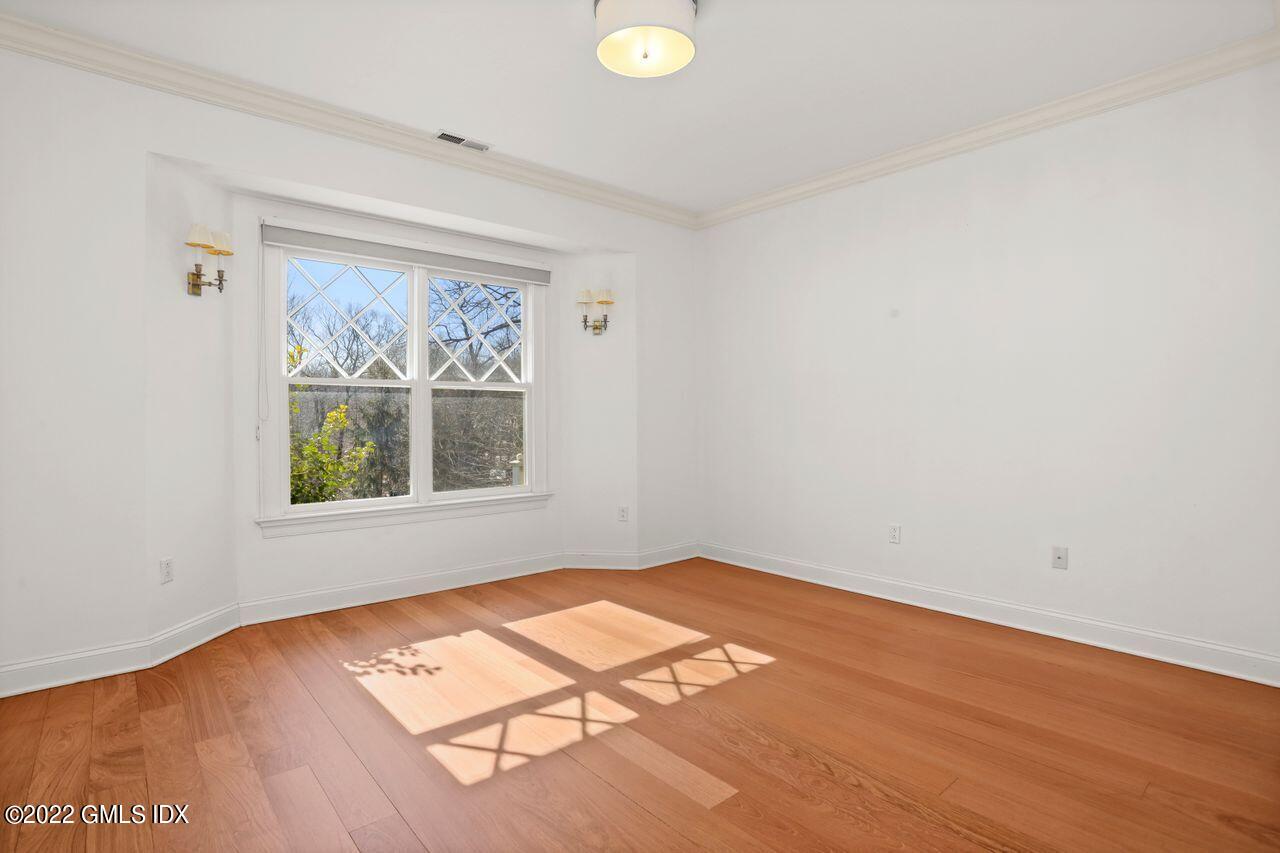 56 Frontier Road Cos Cob, CT 06807 - Photo 22 of 32 an empty room with wooden floor and windows