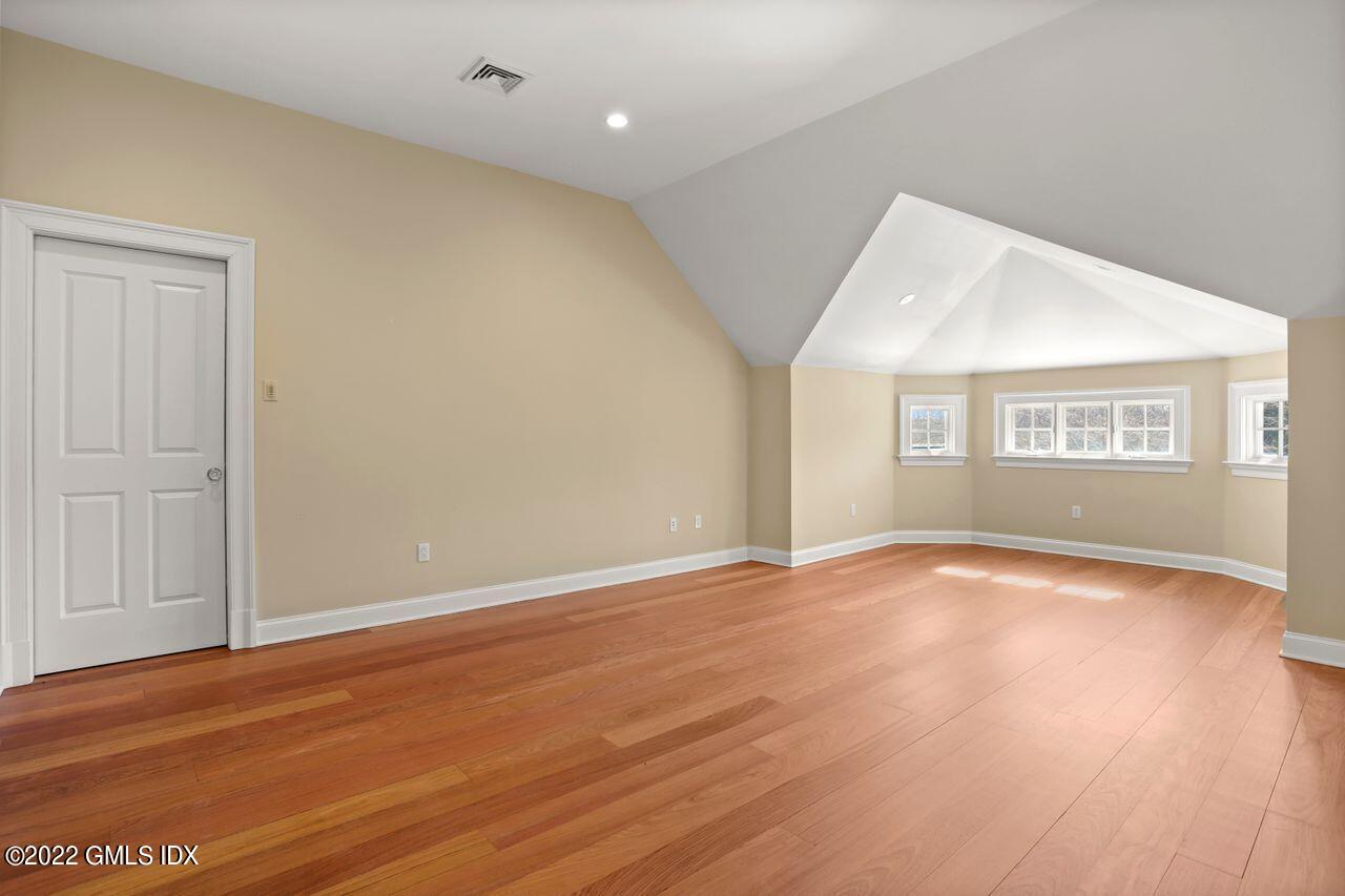 56 Frontier Road Cos Cob, CT 06807 - Photo 23 of 32 an empty room with wooden floor and windows