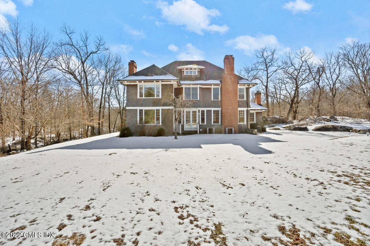 56 Frontier Road Cos Cob, CT 06807 - Photo 28 of 32 a front view of a house with a yard covered in snow