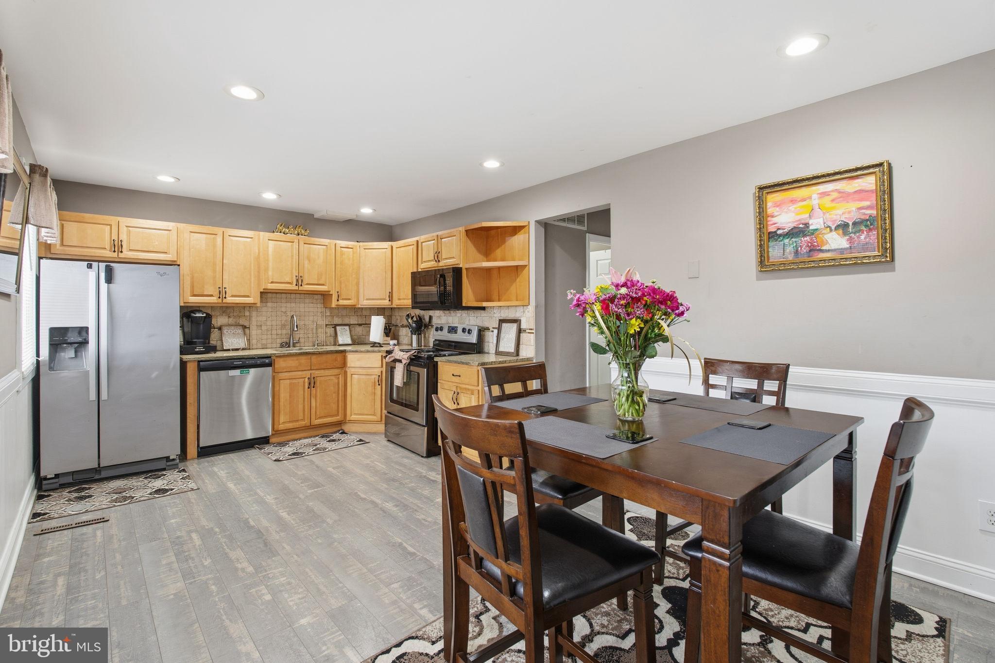 620 Yorkshire Drive Edgewood, MD 21040 - Photo 8 of 31 a kitchen with stainless steel appliances kitchen island granite countertop a dining table chairs and refrigerator