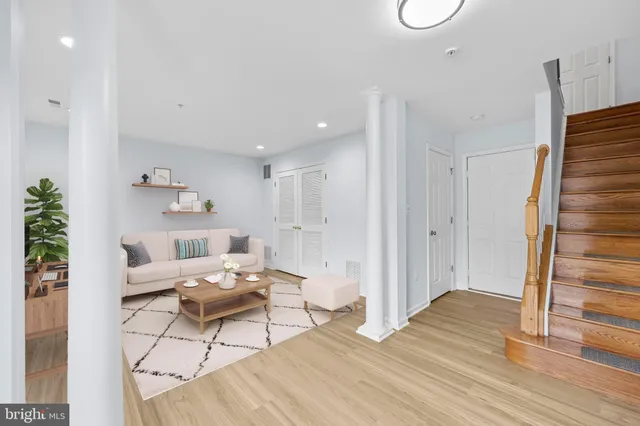 a view of an empty room with wooden floor and a fireplace