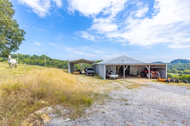 an aerial view of a residential houses with outdoor space and trees