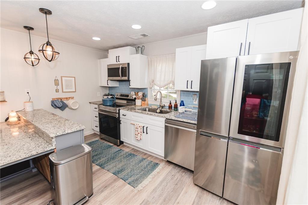 721 Davis Street Monroe, GA 30655 - Photo 8 of 20 a kitchen with stainless steel appliances granite countertop a refrigerator a stove top oven a sink and dishwasher