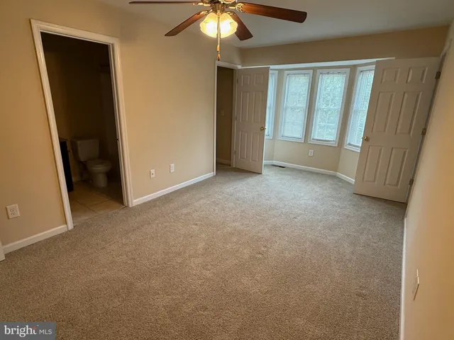 an empty room with chandelier fan