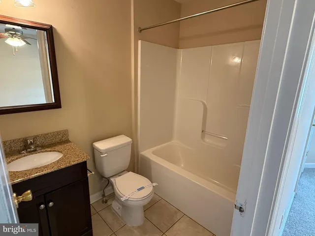 a bathroom with a granite countertop toilet a sink and bathtub