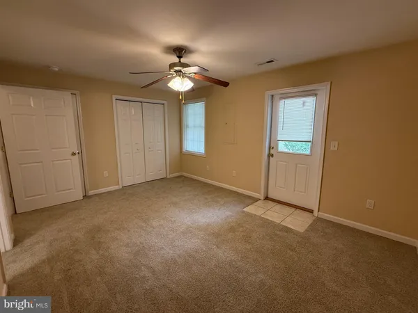 a view of an empty room with a chandelier fan