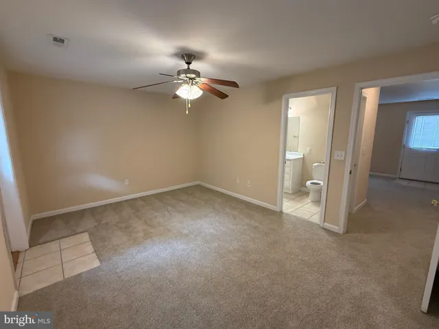 an empty room with closet and a ceiling fan