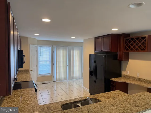 a view of hallway with kitchen island and stainless steel appliances