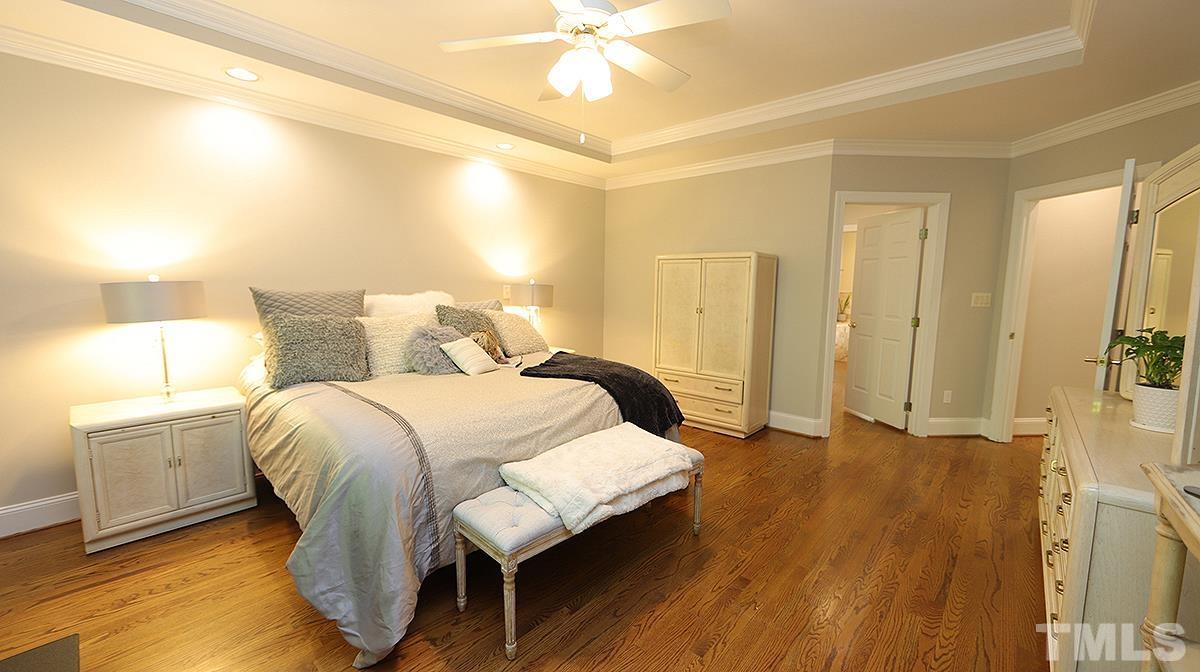 3940 White Chapel Way Raleigh, NC 27615 - Photo 18 of 40 a bedroom with a bed and a chandelier