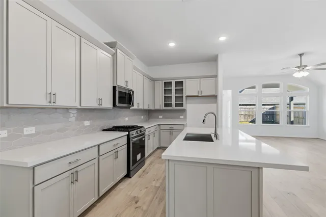 a kitchen with a sink a stove and cabinets