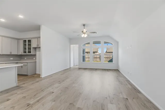 wooden floor in an empty room with a kitchen