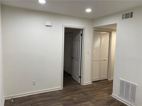 an empty room with wooden floor and closet