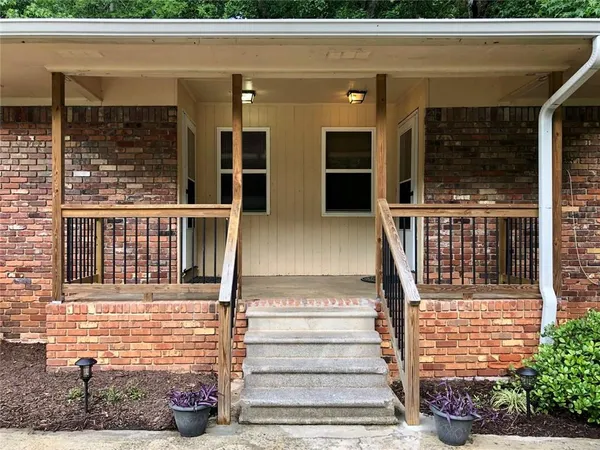 a view of a house with large windows and plants