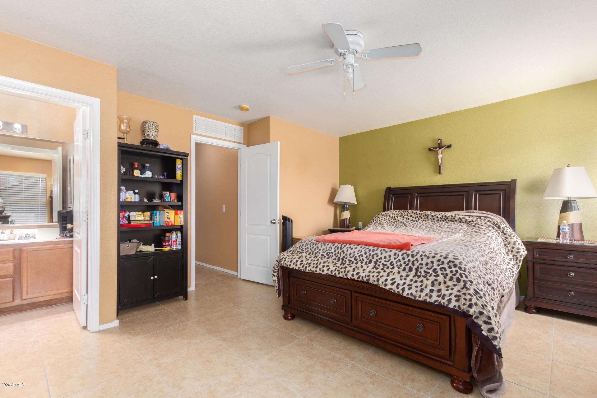 9715 West Payson Road Tolleson, AZ 85353 - Photo 13 of 20 a bedroom with a bed and a walk in closet