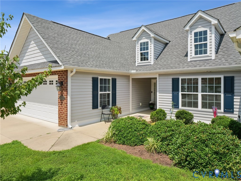 a front view of a house with a yard and plants