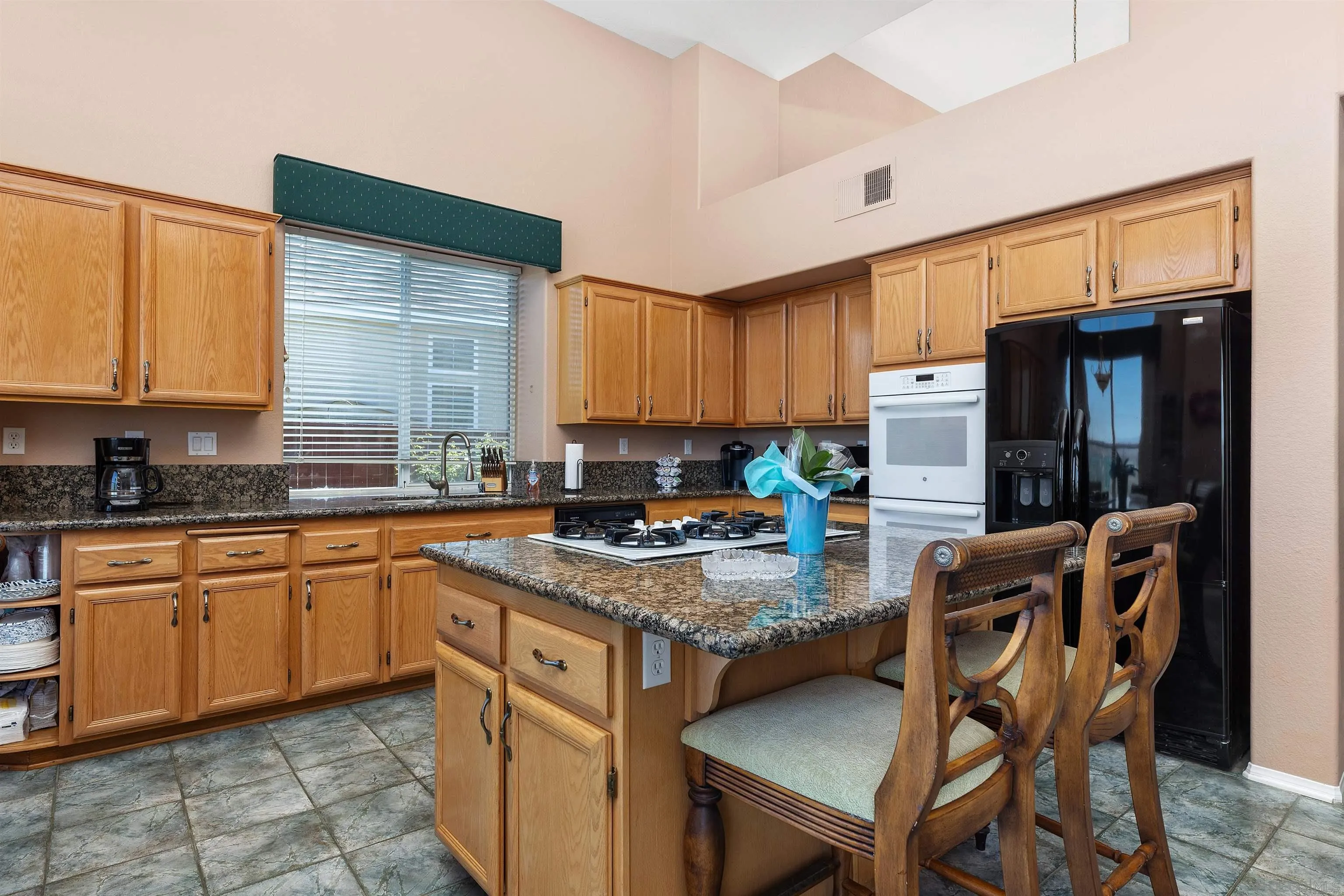 5213 Palmera Drive Oceanside, CA 92056 - Photo 15 of 38 a kitchen with stainless steel appliances granite countertop wooden cabinets a stove top oven a sink and dishwasher