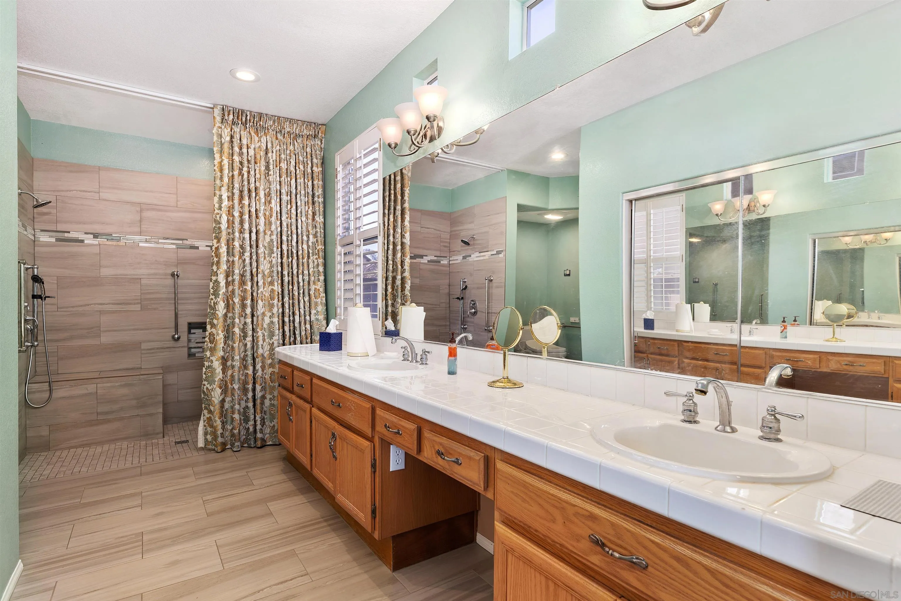 5213 Palmera Drive Oceanside, CA 92056 - Photo 22 of 38 a bathroom with double vanity sinks and a shower