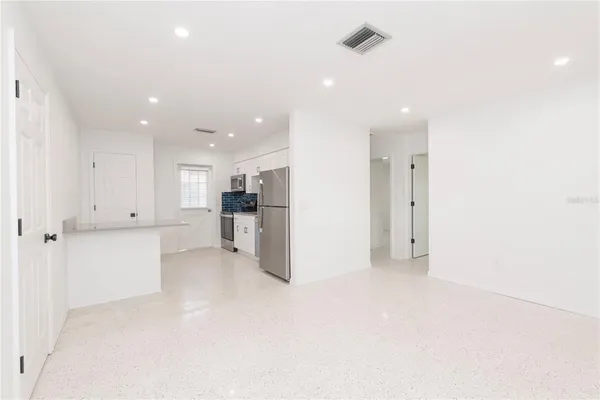 a view of kitchen with white cabinets and stainless steel appliances