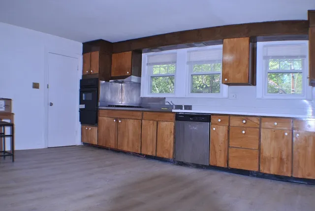 a kitchen with granite countertop a sink and cabinets