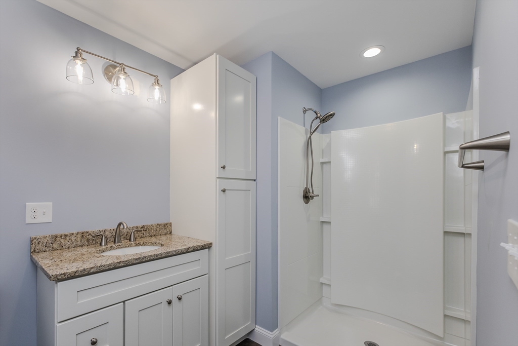 132 Kibbe Road East Longmeadow, MA 01028 - Photo 19 of 32 a bathroom with a granite countertop sink a shower and a mirror