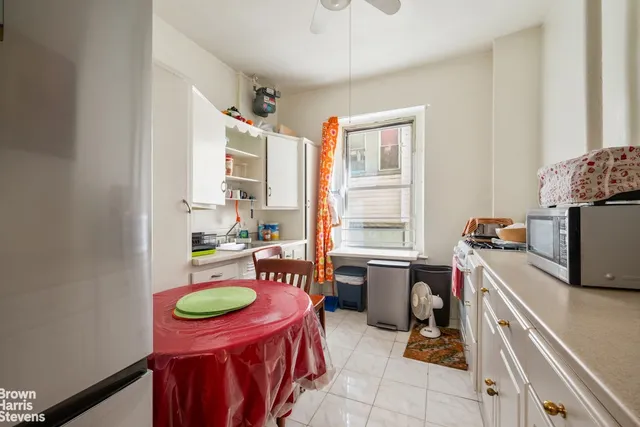 a kitchen with stainless steel appliances granite countertop a refrigerator a sink a stove and white cabinets