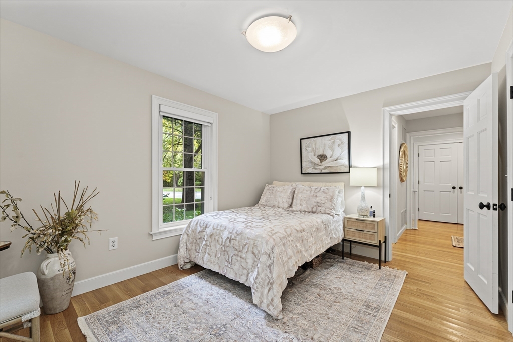 16 Preacher Road, Unit 16 Milton, MA 02186 - Photo 19 of 32 a bedroom with a large bed and a potted plant