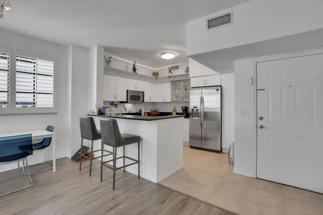 a kitchen with kitchen island white cabinets and stainless steel appliances