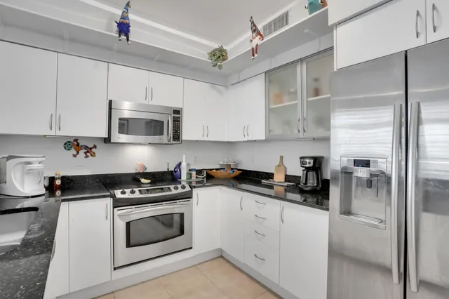 a kitchen with cabinets stainless steel appliances and a counter space