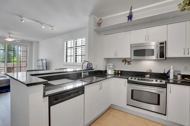 a kitchen with granite countertop a stove sink and microwave