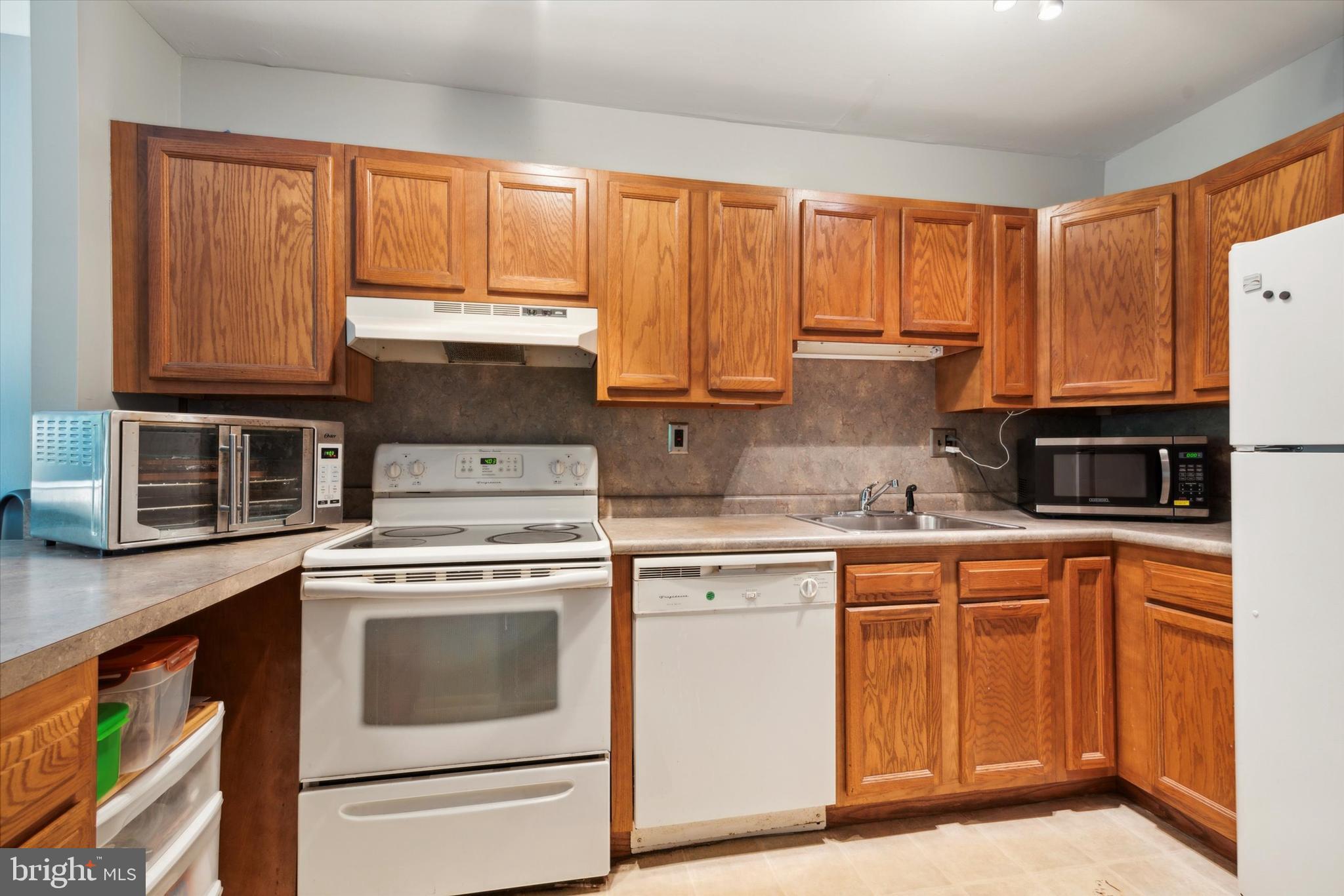 46 Township Line Road, Unit 209 Elkins Park, PA 19027 - Photo 11 of 15 a kitchen with stainless steel appliances granite countertop a stove a sink and a microwave