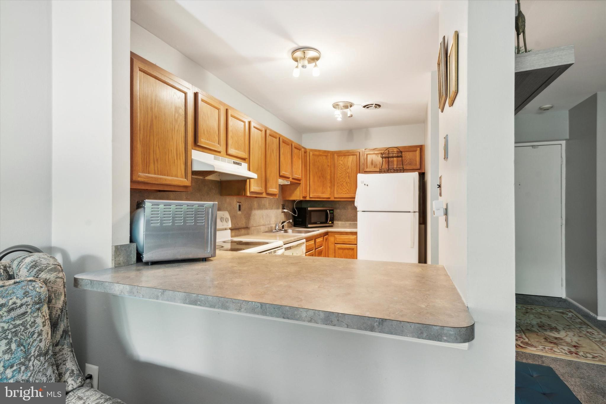 46 Township Line Road, Unit 209 Elkins Park, PA 19027 - Photo 7 of 15 a kitchen with stainless steel appliances granite countertop a refrigerator a stove and a sink with granite countertops