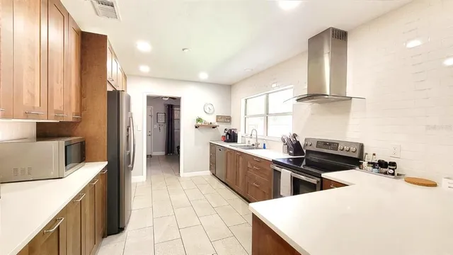 a kitchen with stainless steel appliances a stove a sink a refrigerator and a refrigerator