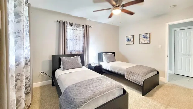 a spacious bedroom with two beds and a chandelier