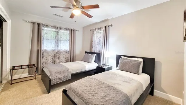 a bedroom with two beds and window